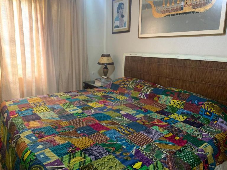 Habitación doble con colorida colcha patchwork africana en Beach Vue Barbados