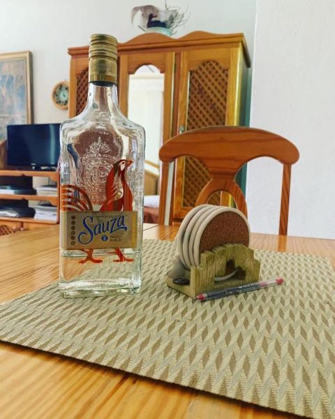 Botella de tequila Sauza Gold sobre mesa de comedor de madera en Beach Vue Barbados