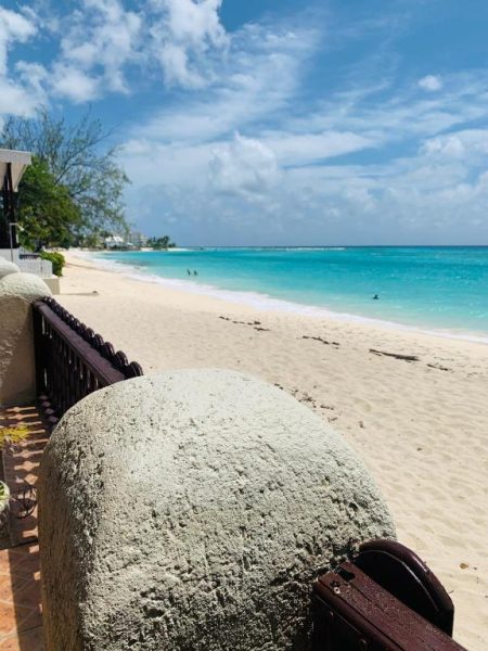 Vista panorámica de la playa de arena blanca y mar turquesa desde la terraza del Beach Vue Barbados