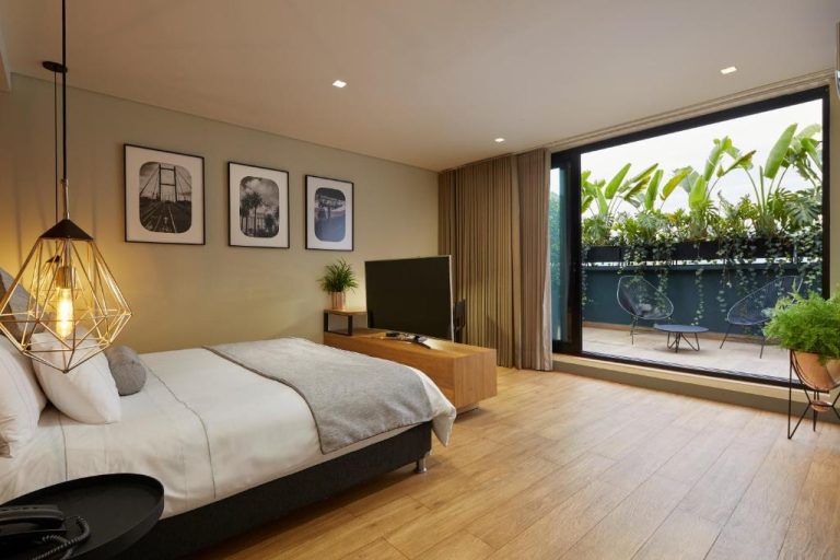 Habitación moderna con cama doble y terraza con plantas tropicales en 14 Urban Hotel