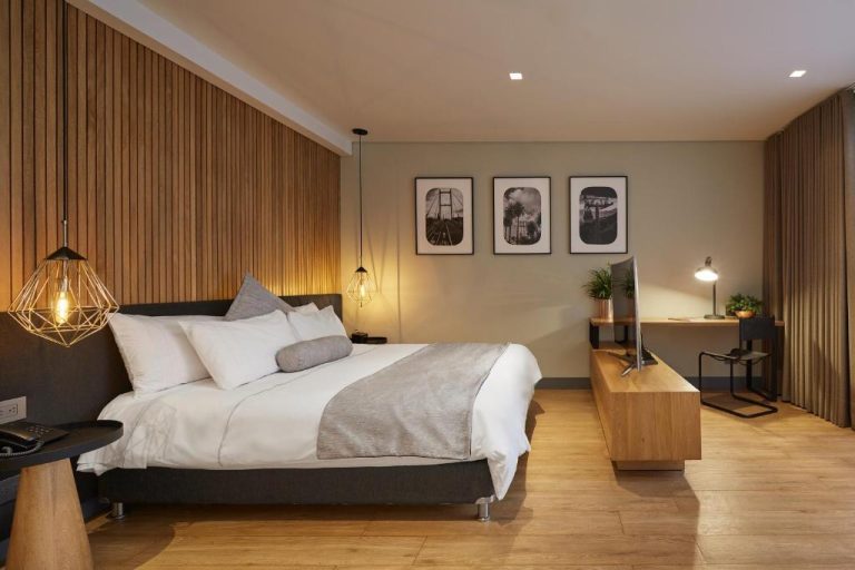 Habitación doble de diseño moderno con cama king y panel de madera en 14 Urban Hotel