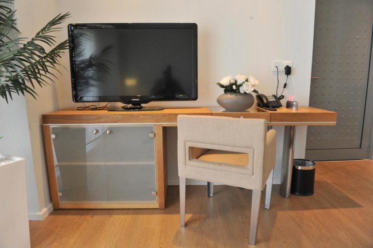 Escritorio de madera con televisión Philips y teléfono en habitación del E-Hotel Larnaca Resort & Spa