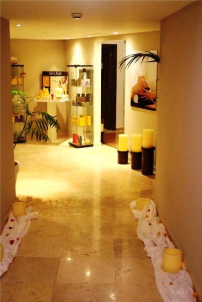 Pasillo del spa con velas decorativas y zona de tratamientos en E-Hotel Larnaca Resort & Spa