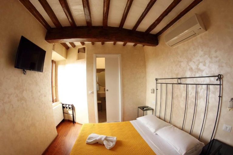 Habitación rústica con vigas de madera y cama doble en Primavera Mini Hotel