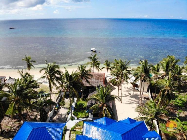 Vista aérea del Lanas Beach Resort en Carabao Island con palmeras, tejados azules y aguas cristalinas