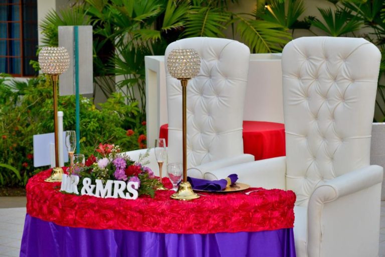 Mesa de novios decorada con flores y candelabros en boda al aire libre del hotel Coco La Palm