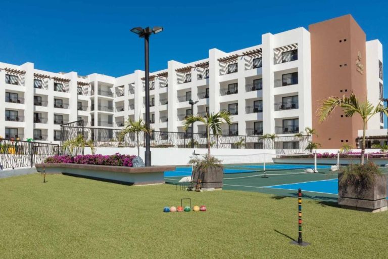 Pistas de tenis y jardines del Medano Hotel and Spa con canchas azules y zona de croquet