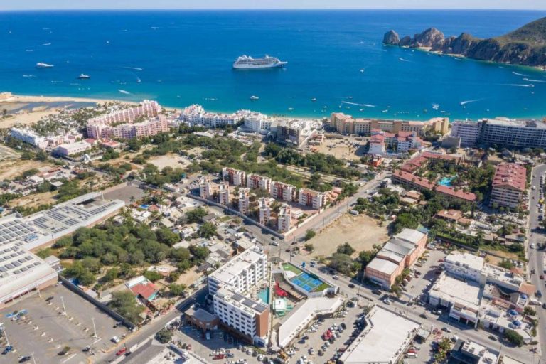 Vista aérea del Medano Hotel and Spa con playa, mar turquesa y crucero en Cabo San Lucas