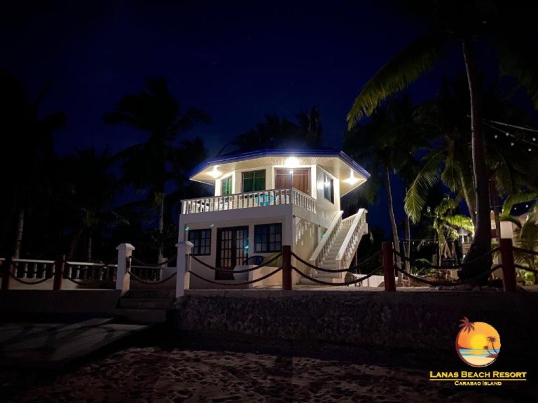 Villa frente al mar iluminada de noche en Lanas Beach Resort de Carabao Island, Filipinas