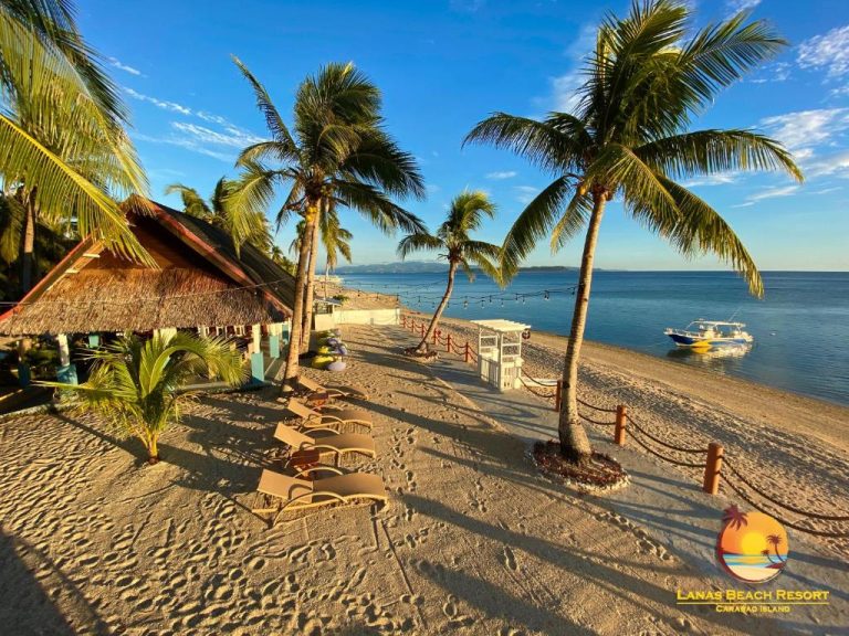 Playa de arena blanca con palmeras y tumbonas del Lanas Beach Resort en Carabao Island, Filipinas