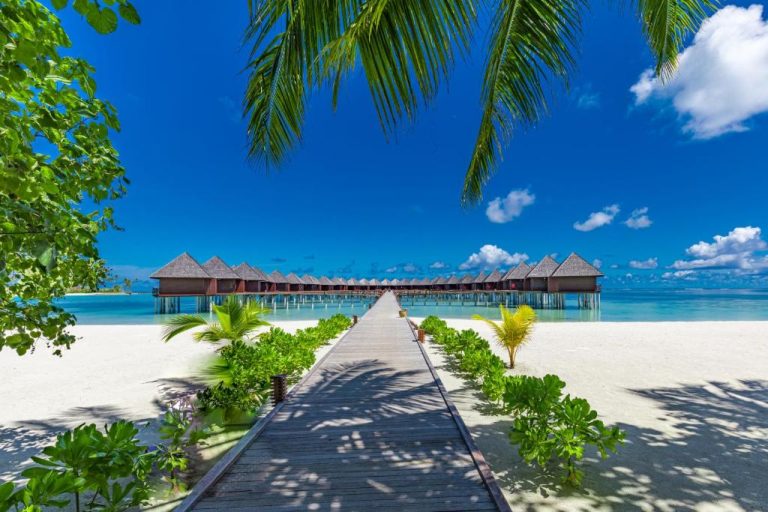 Pasarela de madera hacia bungalows sobre el agua en Sun Siyam Olhuveli, Maldivas