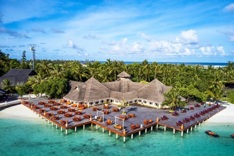 Restaurante sobre el agua con terraza y mesas del resort Sun Siyam Olhuveli en Maldivas