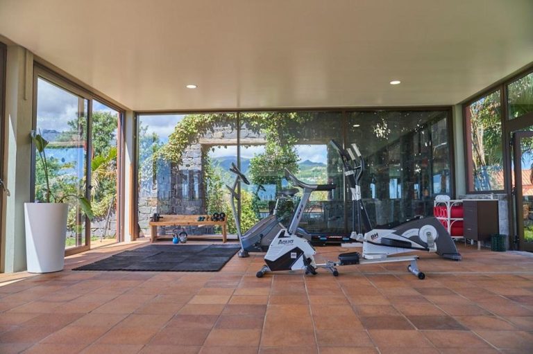 Gimnasio con bicicletas estáticas y vistas panorámicas al jardín en Hotel Quinta do Furao