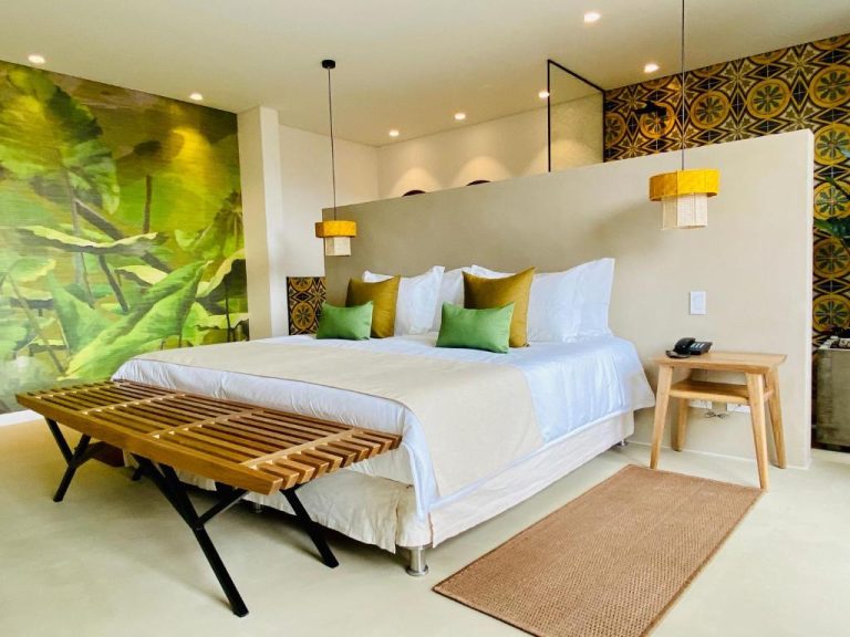 Habitación deluxe con cama king size y decoración tropical en el hotel Patio del Mundo