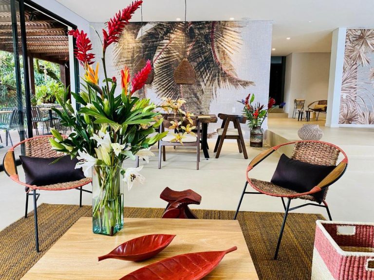 Lobby del Patio del Mundo con decoración tropical, flores exóticas y sillones de mimbre