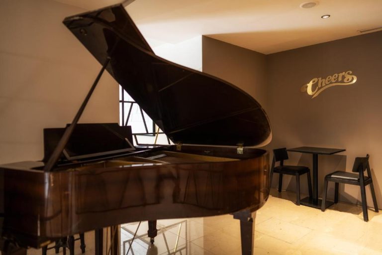 Piano de cola y zona de bar Cheers en el Hotel Girassol Suite Hotel, ambiente elegante