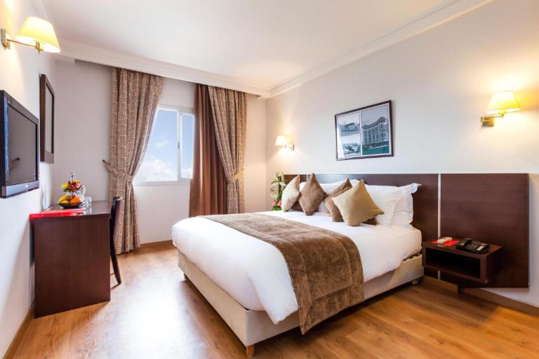 Habitación doble con cama matrimonial y suelo de madera en Relax Hotel Airport Nouasseur