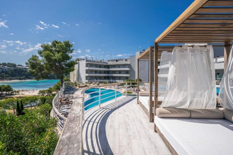Piscina exterior con tumbonas y vistas a la playa del hotel ARTIEM Audax Adults Only en Menorca