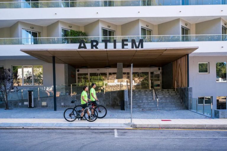 Dos ciclistas frente a la entrada principal del hotel ARTIEM Audax Adults Only en Menorca