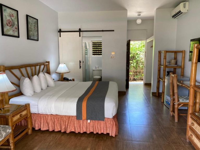 Habitación doble con cama king, muebles de bambú y baño privado en Toby's Resort