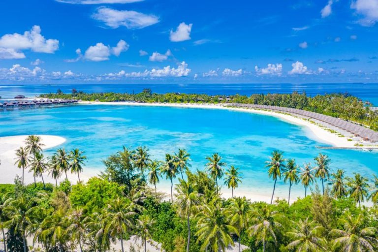 Vista aérea de la laguna turquesa y playa de arena blanca del resort Sun Siyam Olhuveli en Maldivas