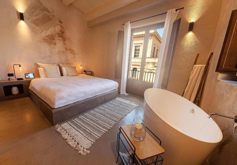 Habitación de lujo con bañera exenta y cama doble en Casa Nostra Boutique Hotel & Spa