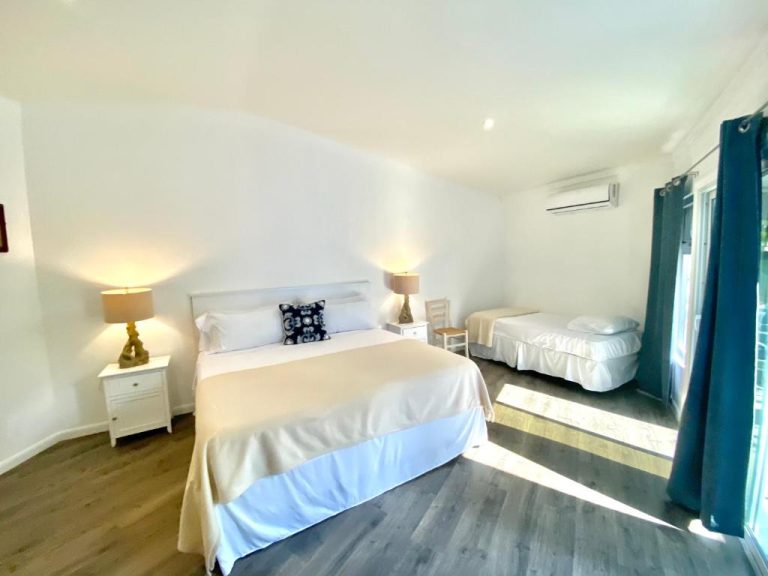 Habitación doble con cama matrimonial y cama individual en The Sunset Cove and Rainbow Room