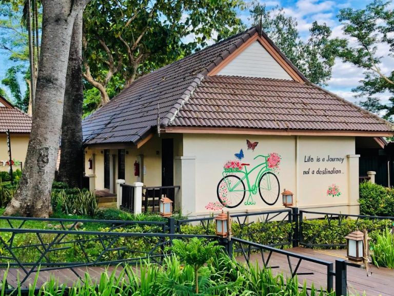 Bungalow con jardines tropicales y mural decorativo en Chiangkhong Teak Garden Riverfront Onsen Hotel