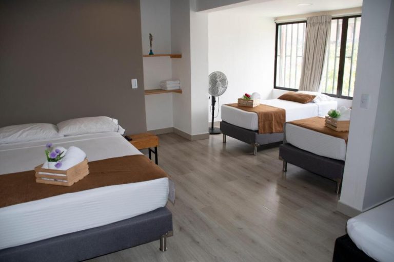 Habitación múltiple con tres camas y decoración moderna en Hotel Boutique Plaza