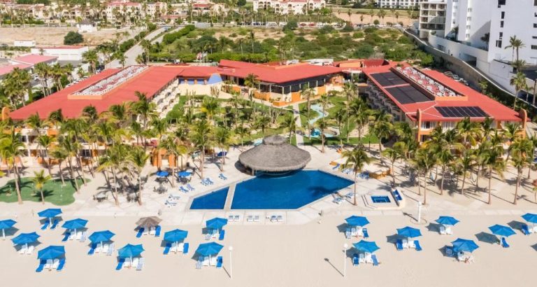 Vista aérea de la piscina exterior y playa con tumbonas azules del Posada Real Los Cabos