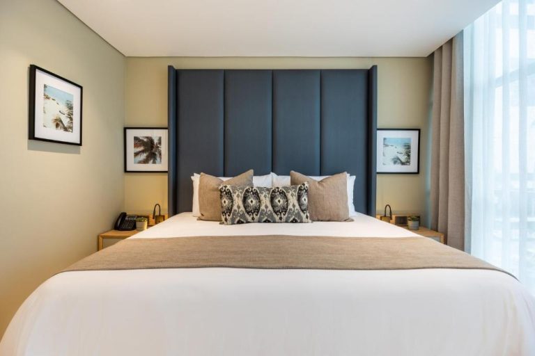Habitación de lujo con gran cabecero azul y cama doble en Oz Hotel Luxury