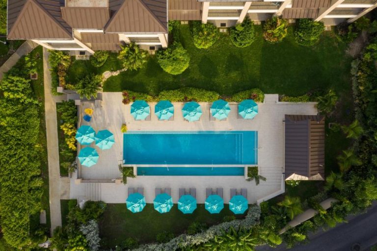 Vista aérea de la piscina exterior con tumbonas y sombrillas turquesas del Beach View Hotel