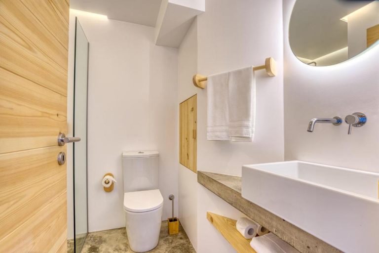 Baño moderno con lavabo empotrado, inodoro y detalles en madera natural del Socalco Nature Calheta