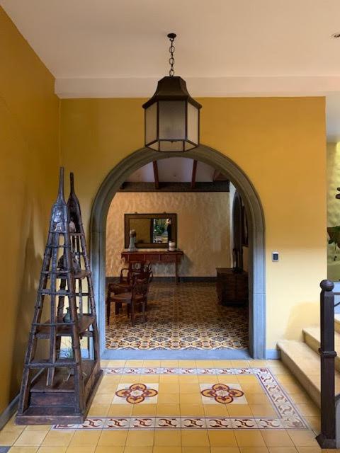 Entrada con arco colonial y azulejos decorativos del Hotel 1915 Inn & Suites con lámpara colgante de hierro