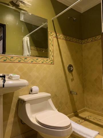 Baño completo con ducha independiente y decoración clásica en Hotel 1915 Inn & Suites