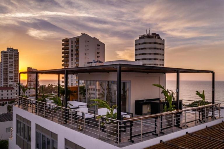 Terraza rooftop con pérgola y vistas al mar al atardecer en Oz Hotel Luxury