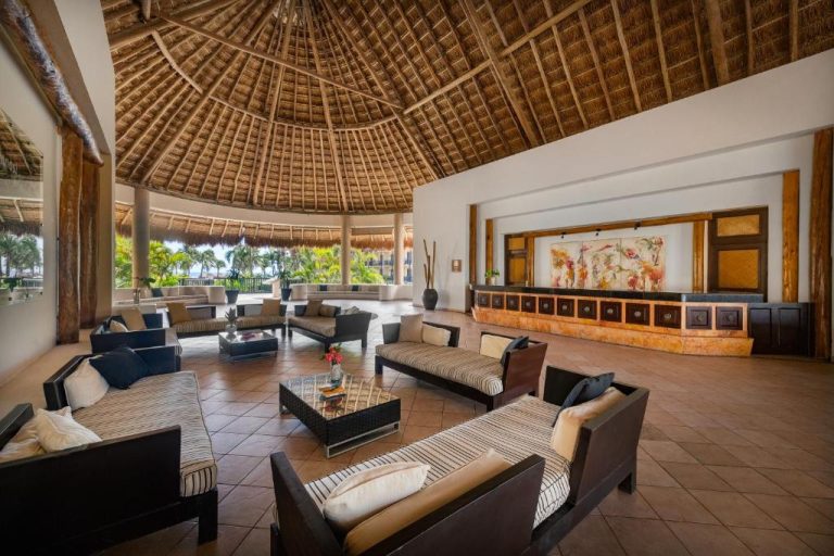 Lobby con techo de palapa y área de recepción del Catalonia Riviera Maya Resort & Spa All Inclusive
