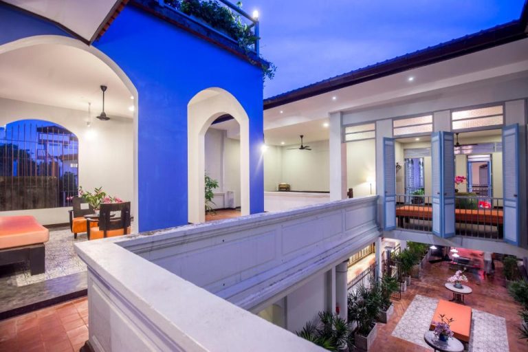 Patio interior colonial con balcones y decoración azul del The Memory at On On Hotel en Phuket