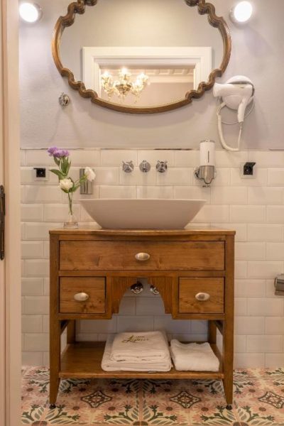 Baño clásico con lavabo sobre mueble de madera y espejo vintage en Hotel Lykia Old Town Antalya