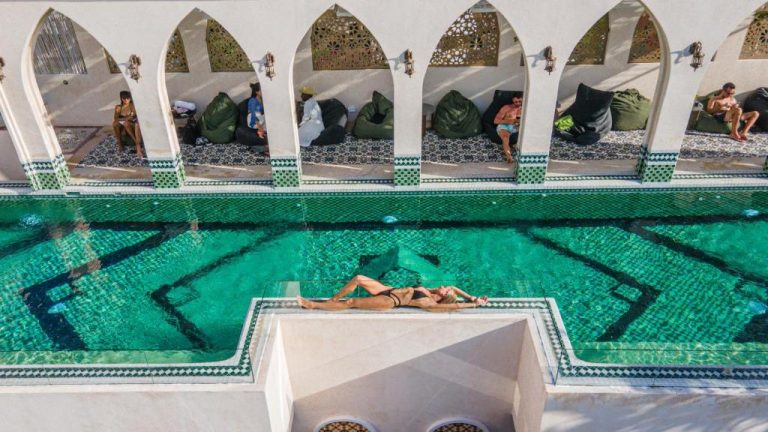 Piscina de mosaicos verdes con arcos de estilo árabe en Layla Tulum Adults Only