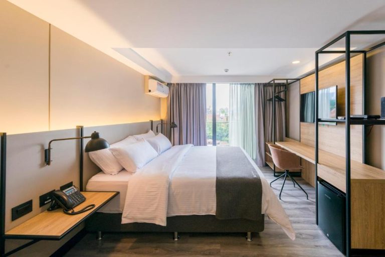 Habitación doble moderna con escritorio de madera y televisor en Lettera Hotel