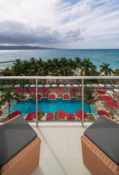 Terraza con tumbonas y piscina exterior con vistas al mar turquesa en S Hotel Montego Bay Jamaica