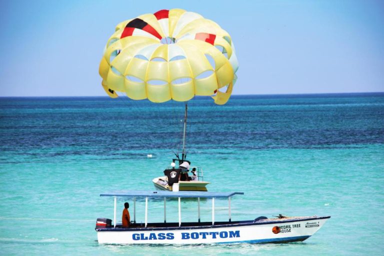 Actividades acuáticas en Negril Treehouse Resort con parasailing y bote de fondo de cristal en el mar