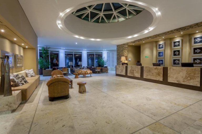Amplio lobby con recepción de mármol y cúpula iluminada del Hotel GHL Corales de Indias