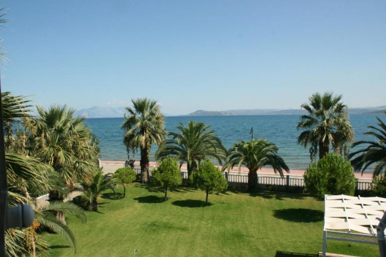 Jardín con palmeras y vistas al mar mediterráneo desde el Batis Hotel con montañas al fondo
