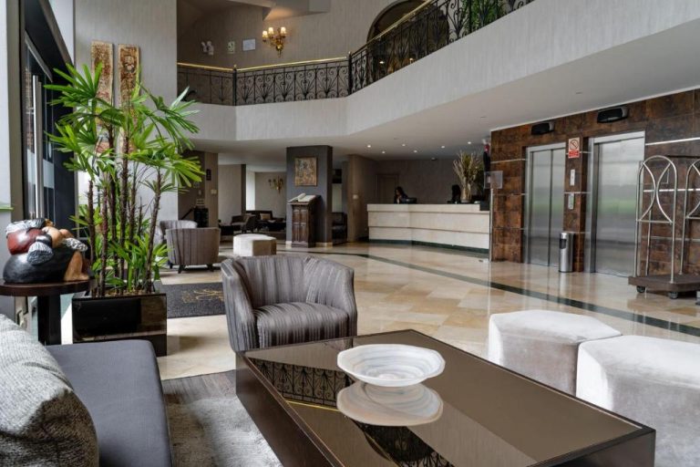 Elegante lobby con recepción, ascensores y zona de descanso del Hotel Jose Antonio