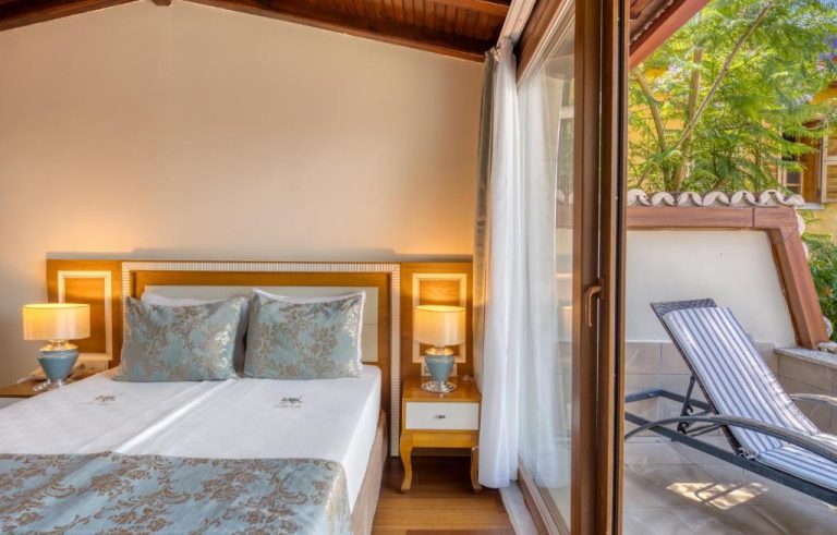 Habitación doble con cama king y terraza exterior con tumbonas en el Dogan Hotel