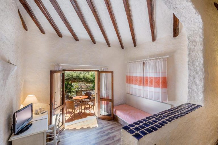 Habitación rústica con vigas de madera, terraza exterior y decoración mediterránea en Hotel Don Diego