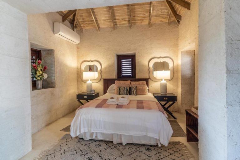 Habitación doble con paredes de piedra y techo de madera en Sweetfield Manor Barbados