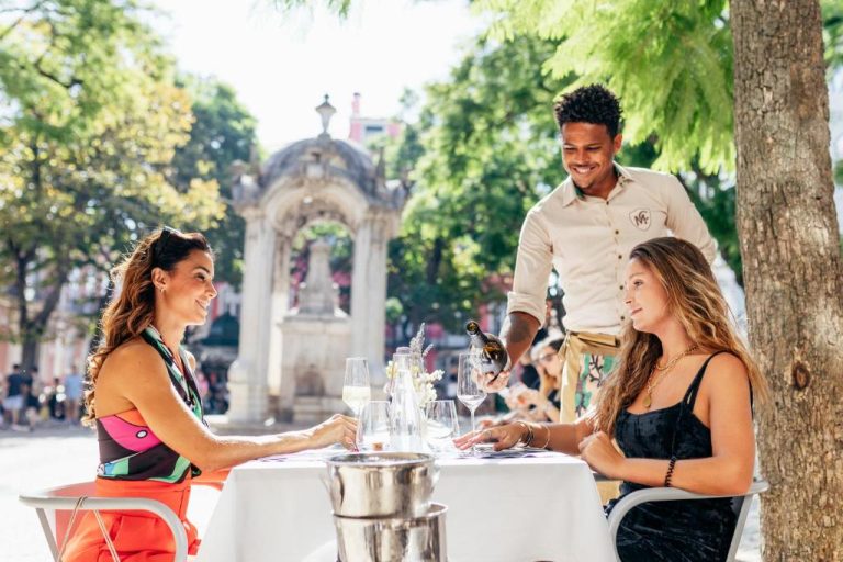 Terraza exterior del Lisboa Carmo Hotel con servicio de vino y vistas a la plaza histórica de Lisboa